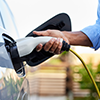 une personne branche une prise de recharge à sa voiture électrique